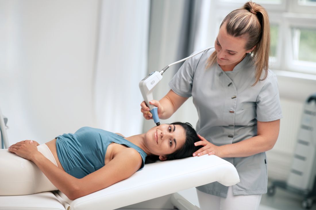 Trattamento del viso con Exilis Ultra 360: l'operatrice passa il manipolo sulla guancia della paziente distesa